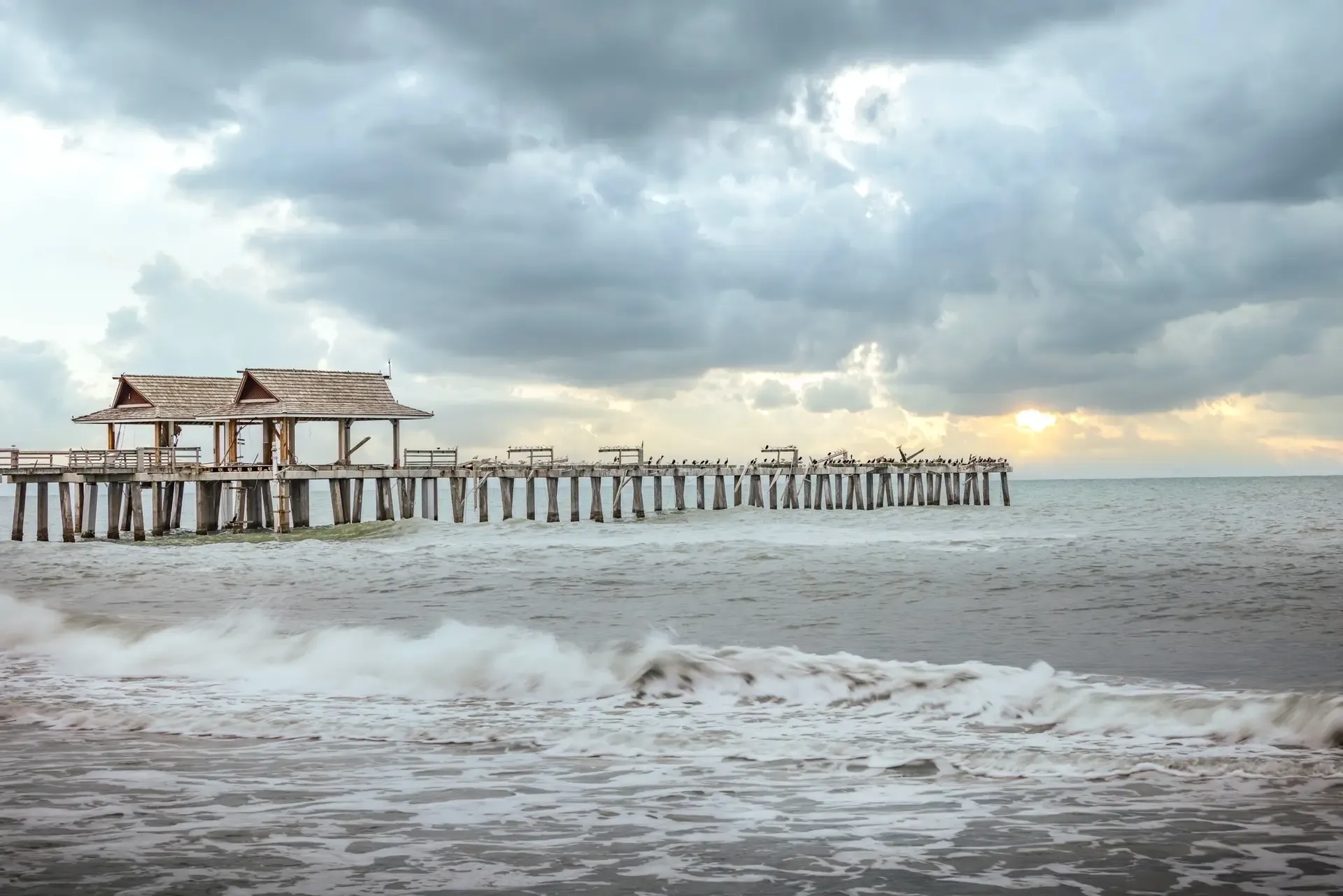 Pier extending into stormy ocean