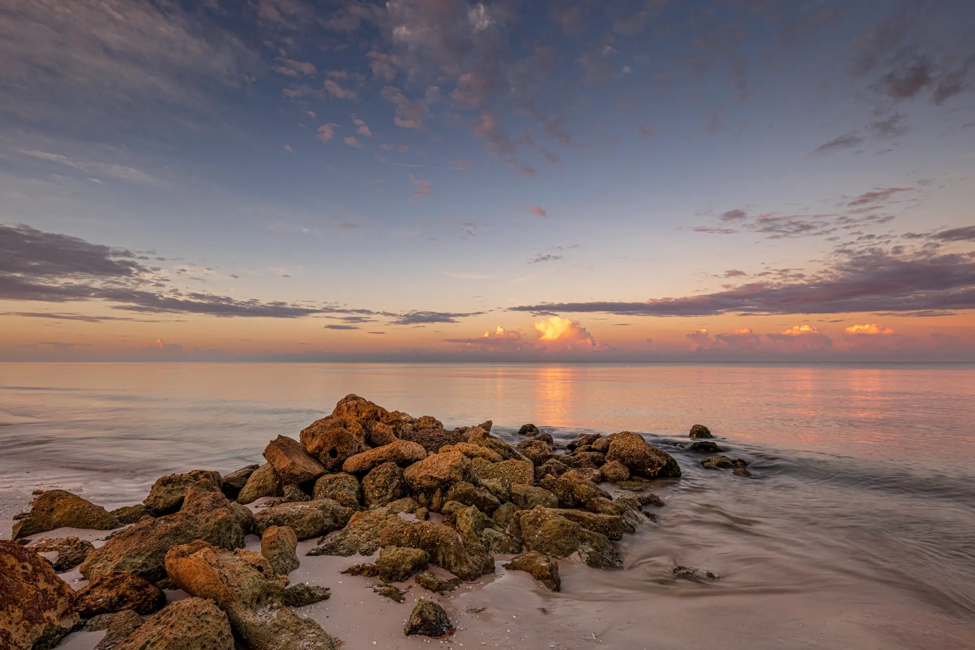 Serene beach at sunset with rocks
