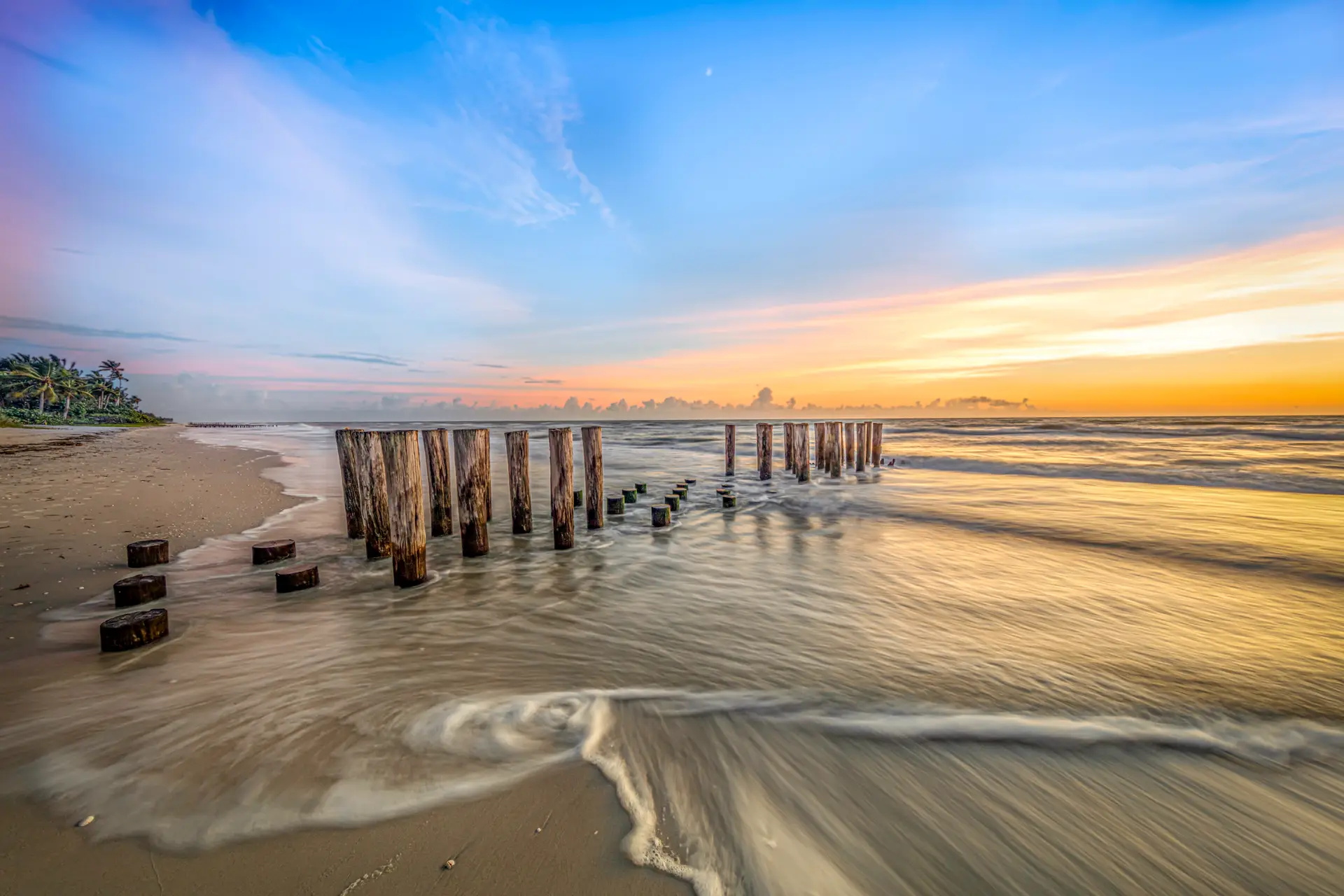 Sunset over beach with pilings