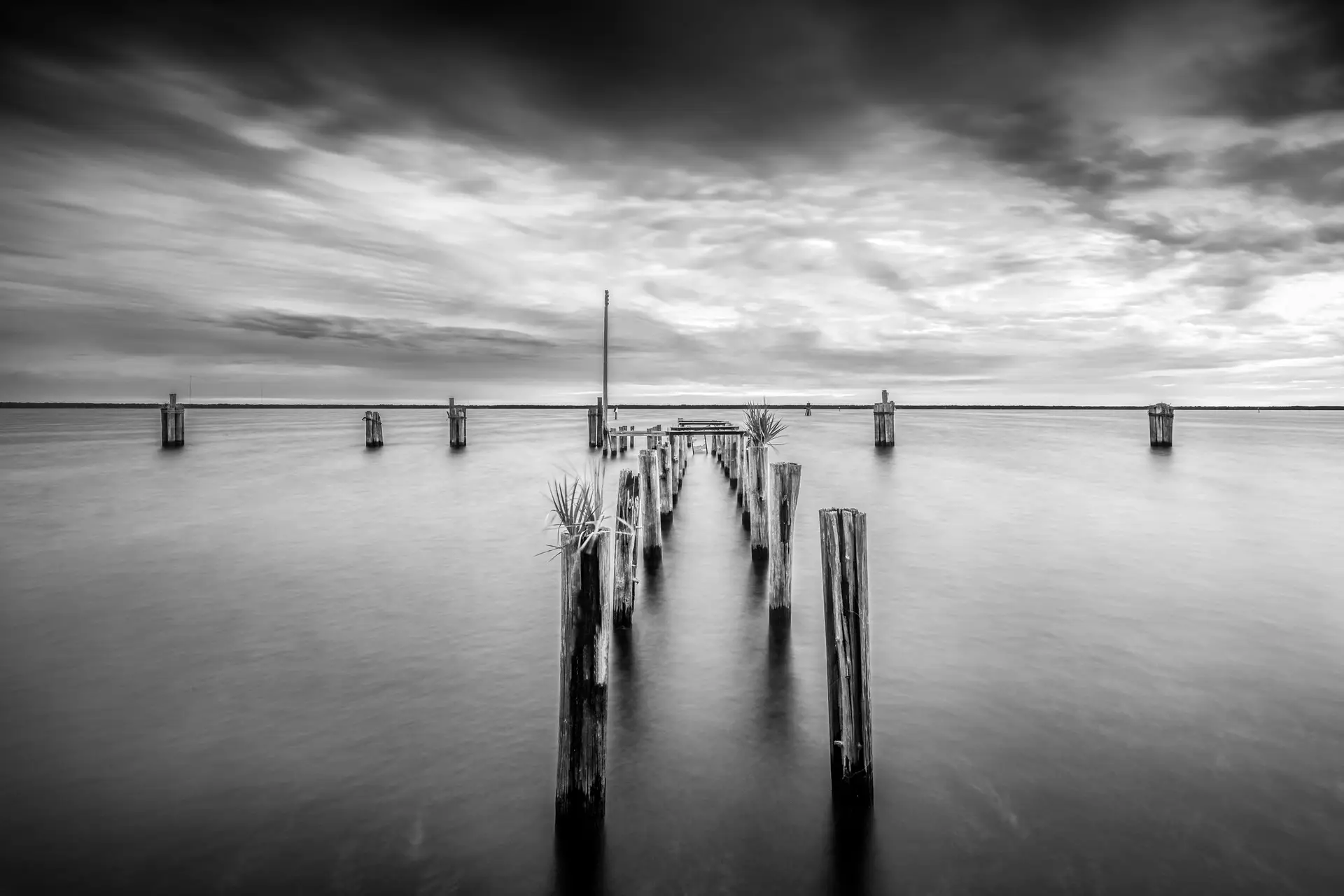 Abandoned pier in tranquil waters.