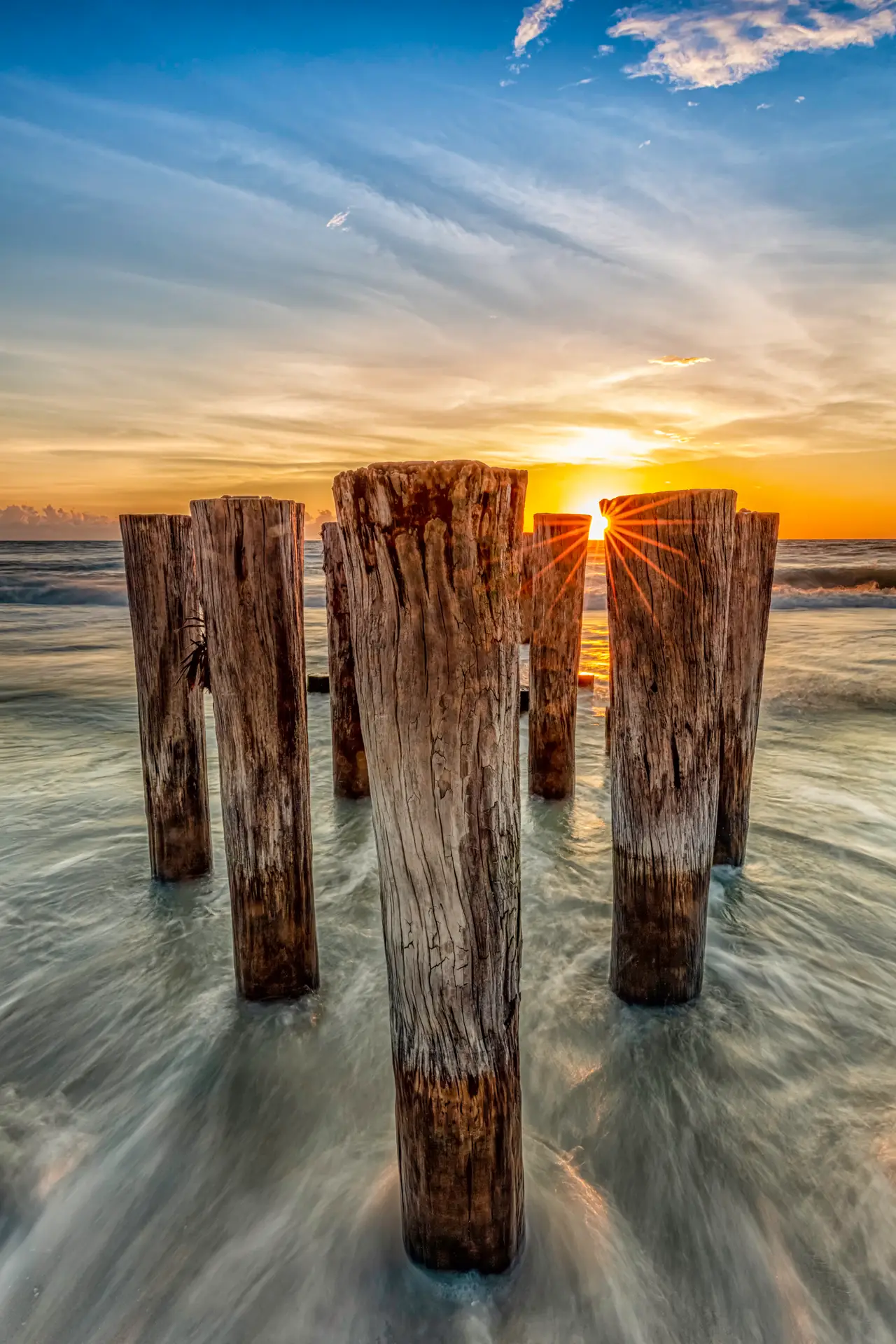 Sunset over wooden pier pilings