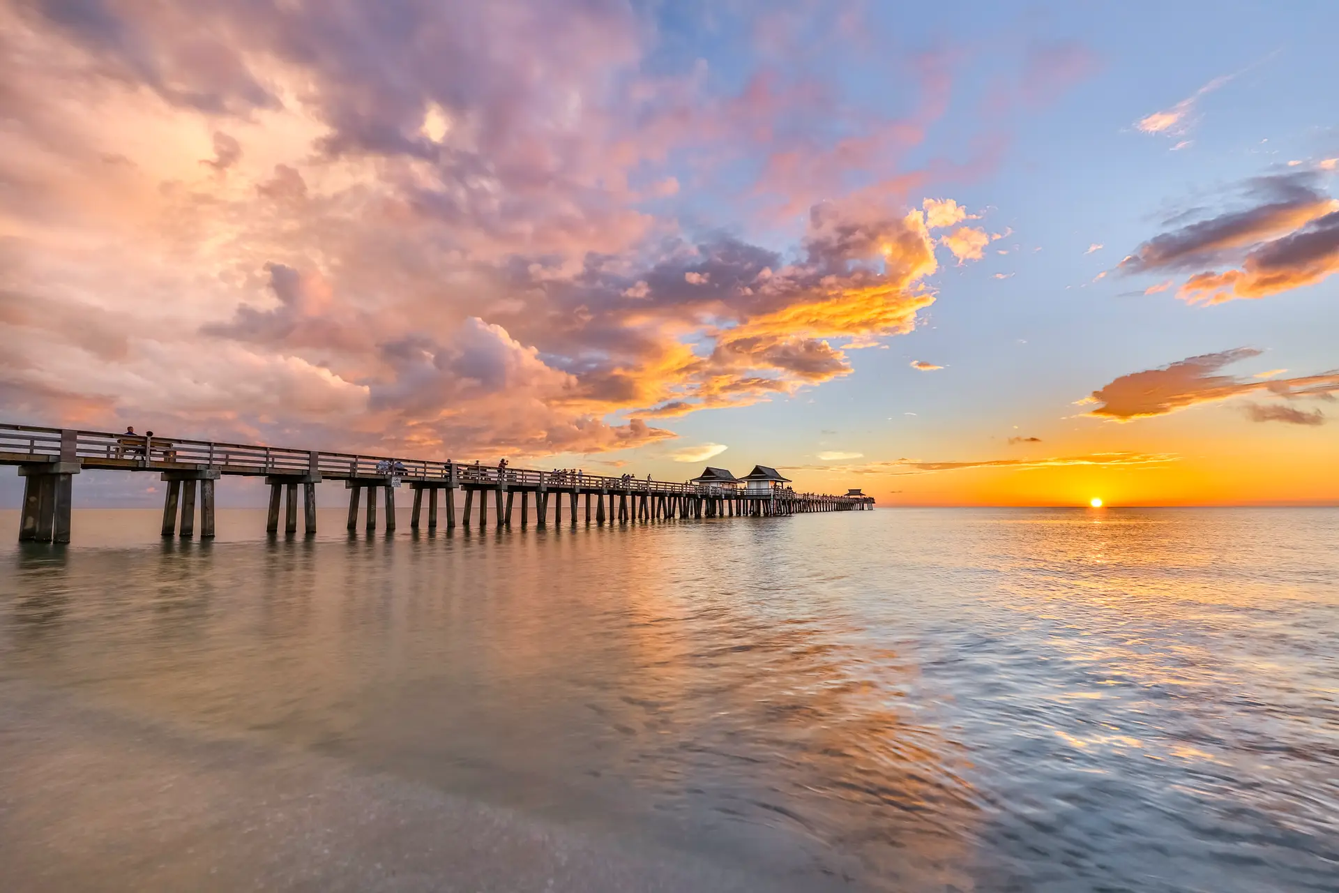 Sunset over calm ocean pier