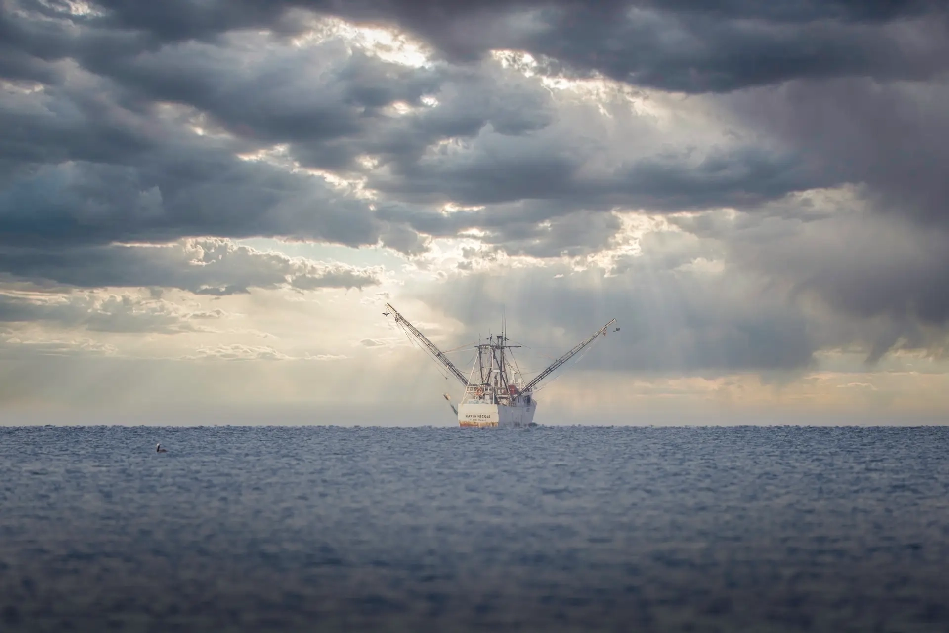 Fishing boat under dramatic cloudy sky