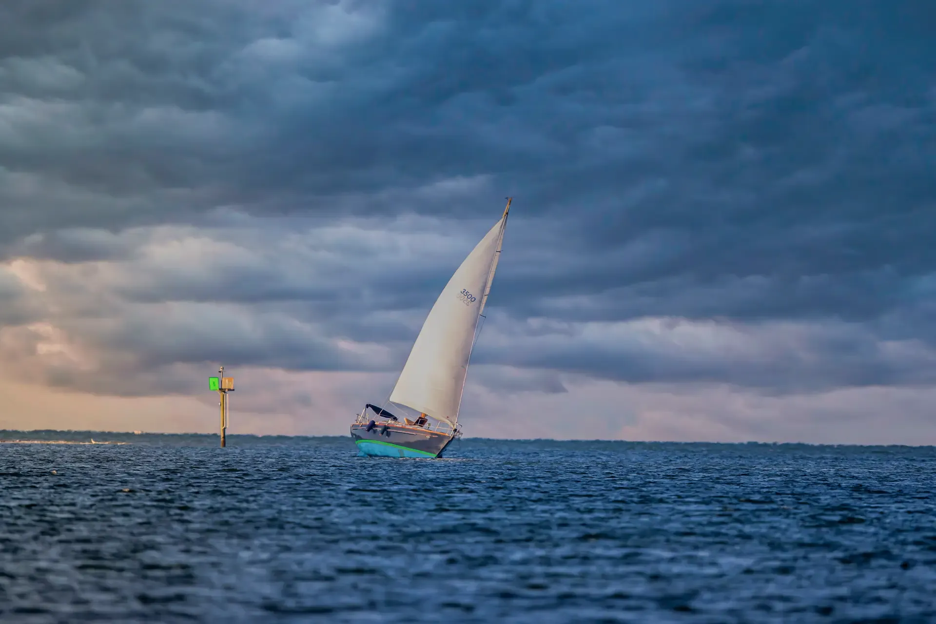 Sailboat navigating under cloudy skies
