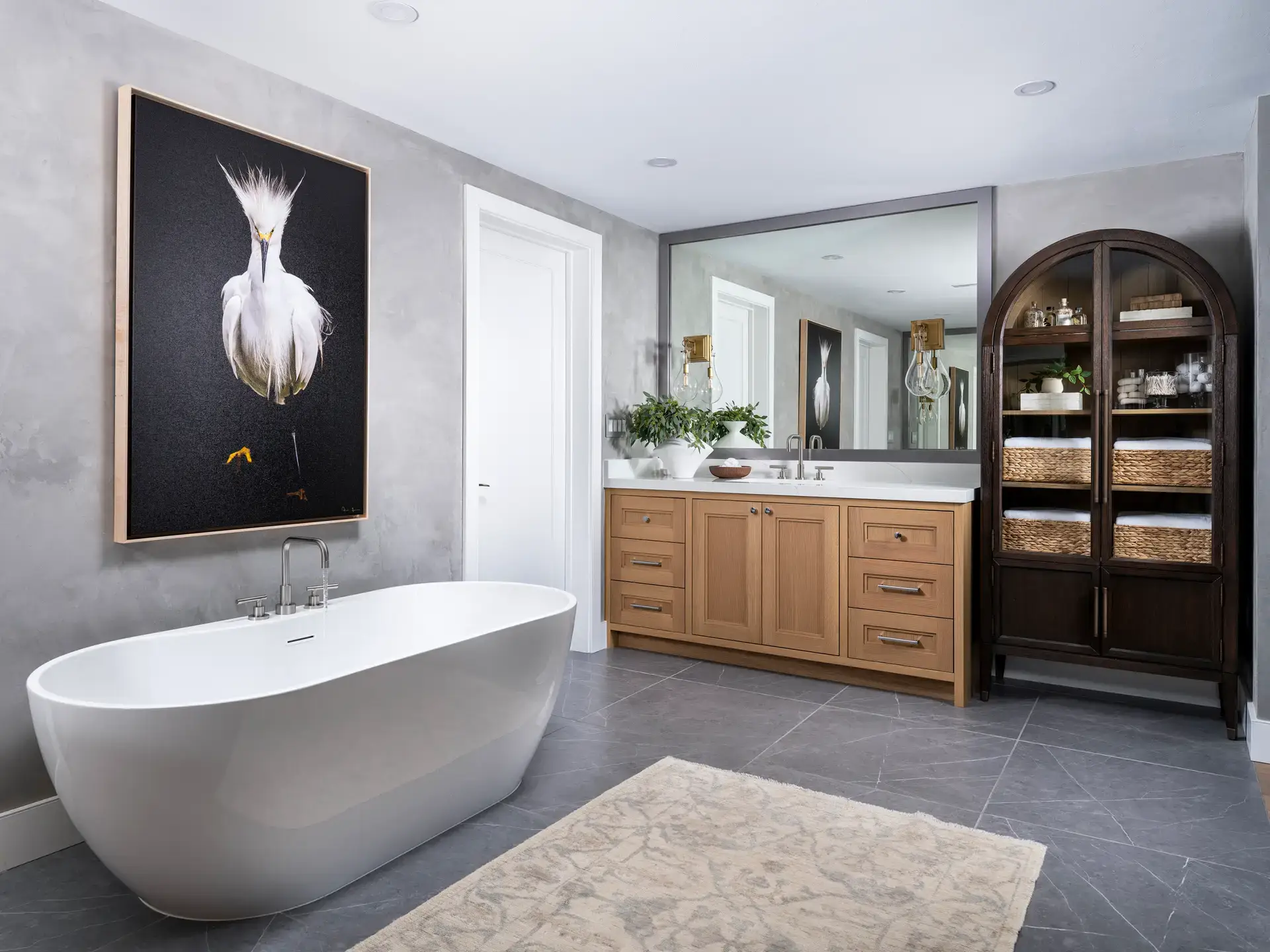 Modern bathroom with freestanding tub and wooden vanity.