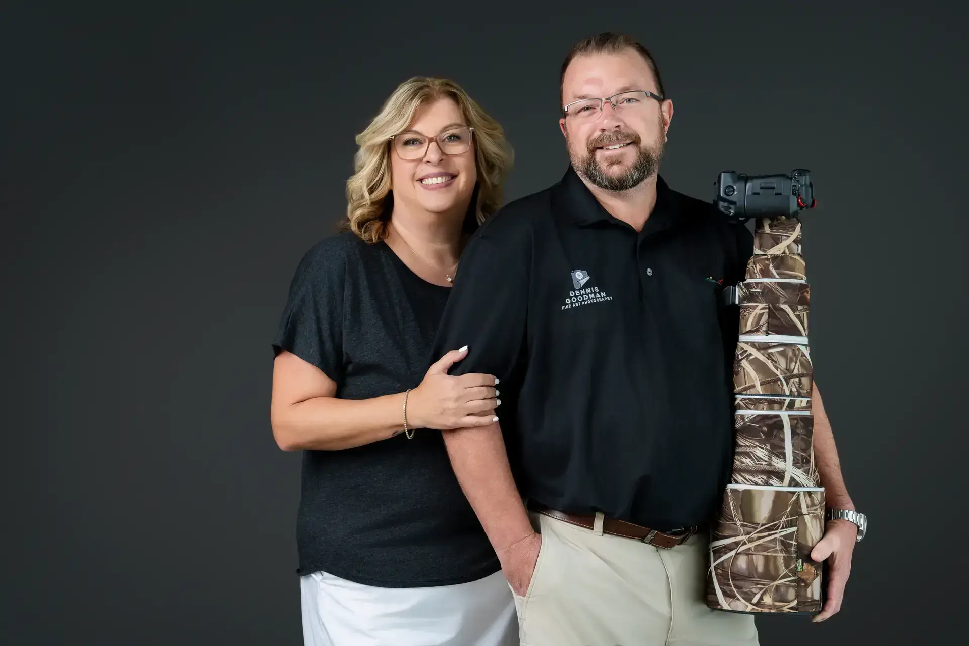 Smiling couple with camouflage-patterned equipment case.