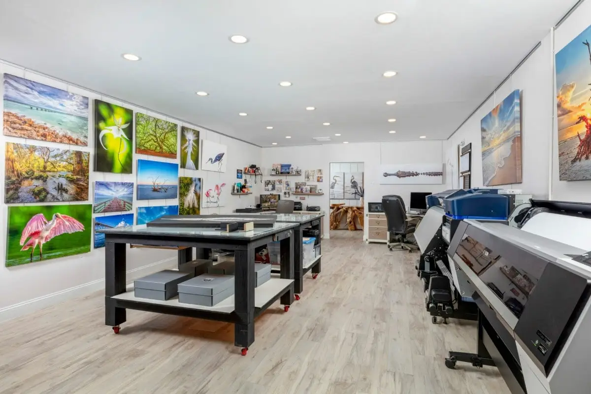 A bright, modern tattoo studio with multiple workstations and colorful wall art.