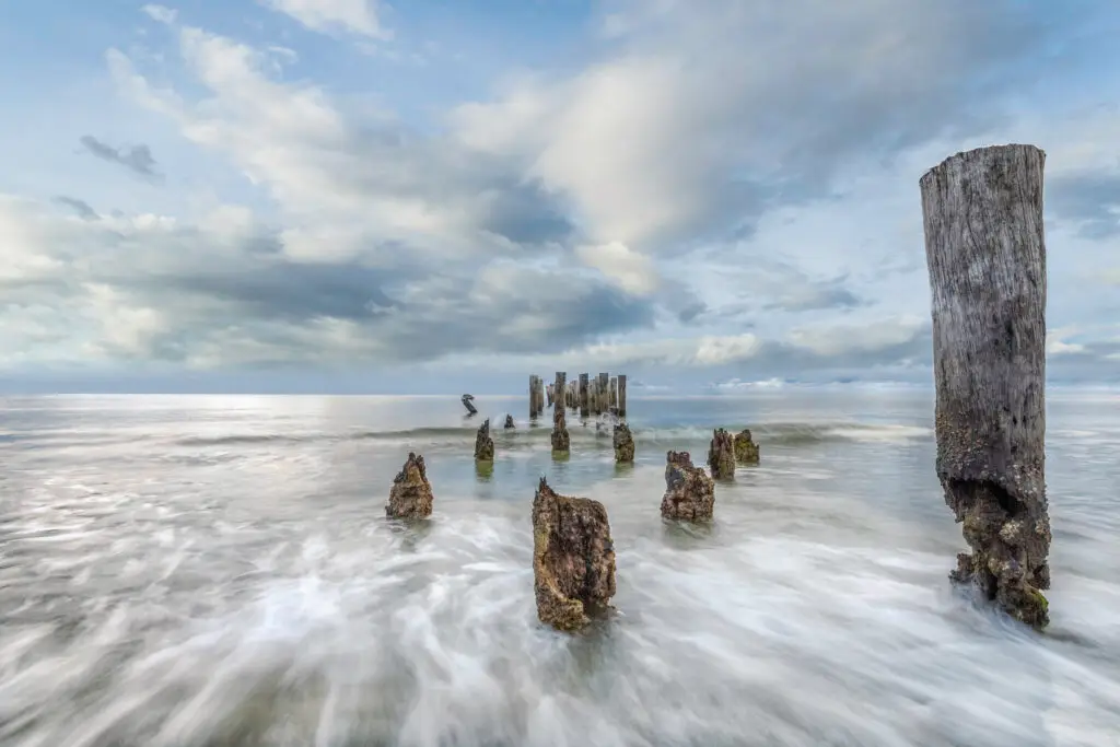 Weathered posts in tranquil ocean waves