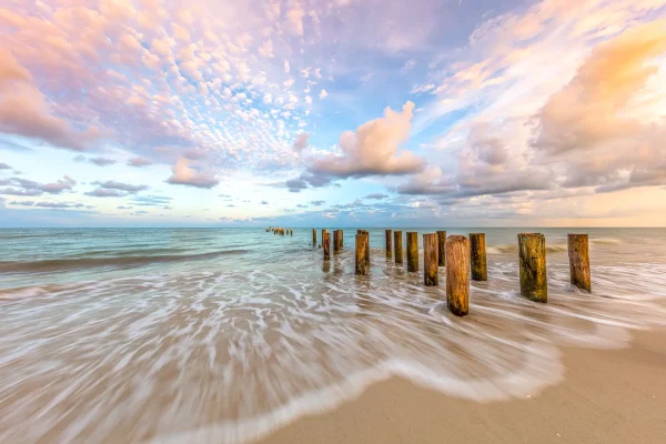 Pilings with water rushing in on beach