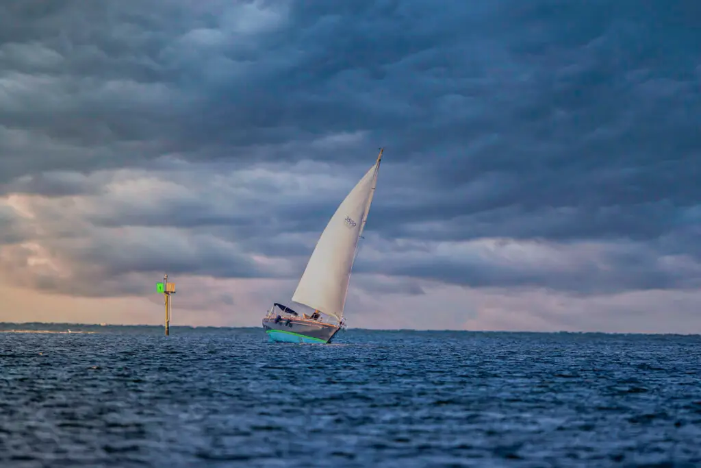 Sailboat navigating under cloudy skies