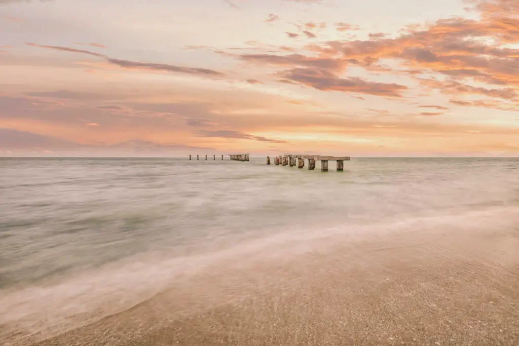 Serene beach at sunset with pier