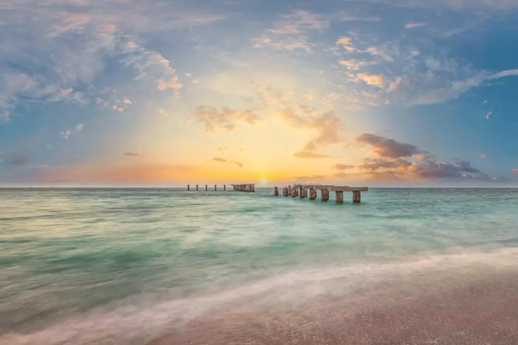 Sunset over tranquil ocean pier